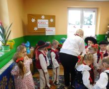 Grupa tańczących dzieci i nauczycielka odwrócona tyłem