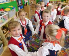 Dzieci tańczą obok półki z zabawkami