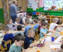 Dzieci malują przy dwóch dużych stołach